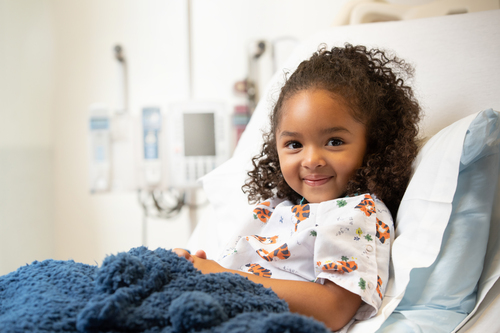 child smiling in hospital bed